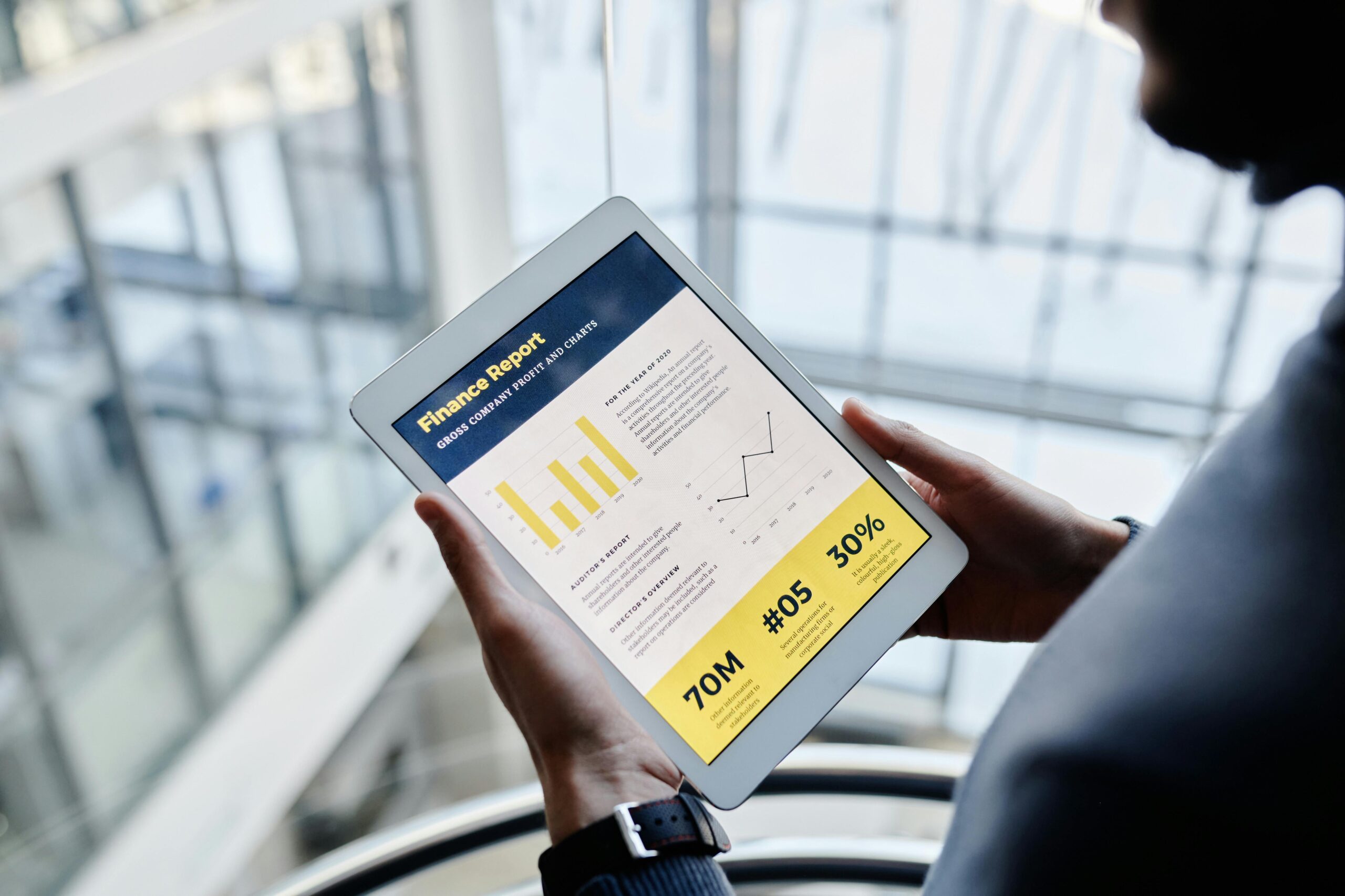Businessman reviewing financial statistics on a tablet indoors.